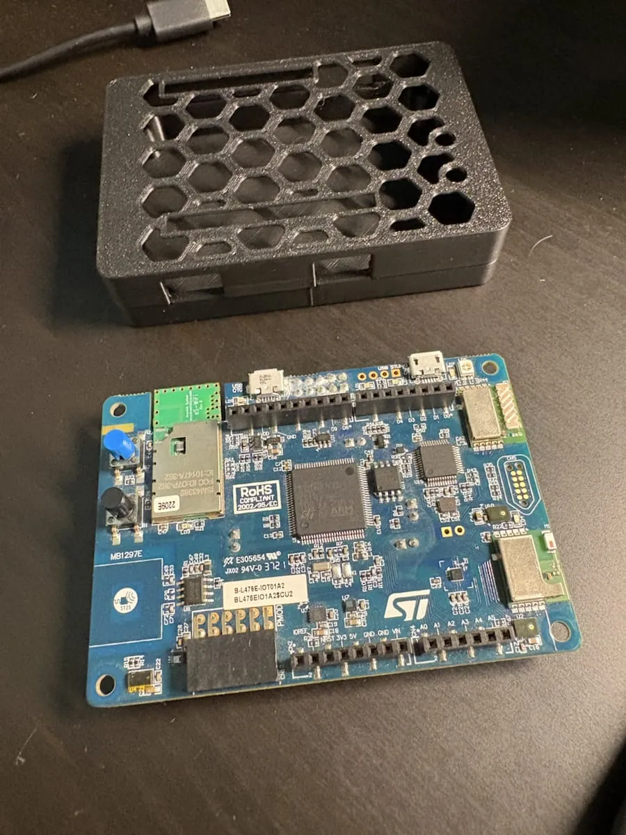 Enclosure body next to the STM32 B-L475E-IOT01A2 board during fit checking before final assembly