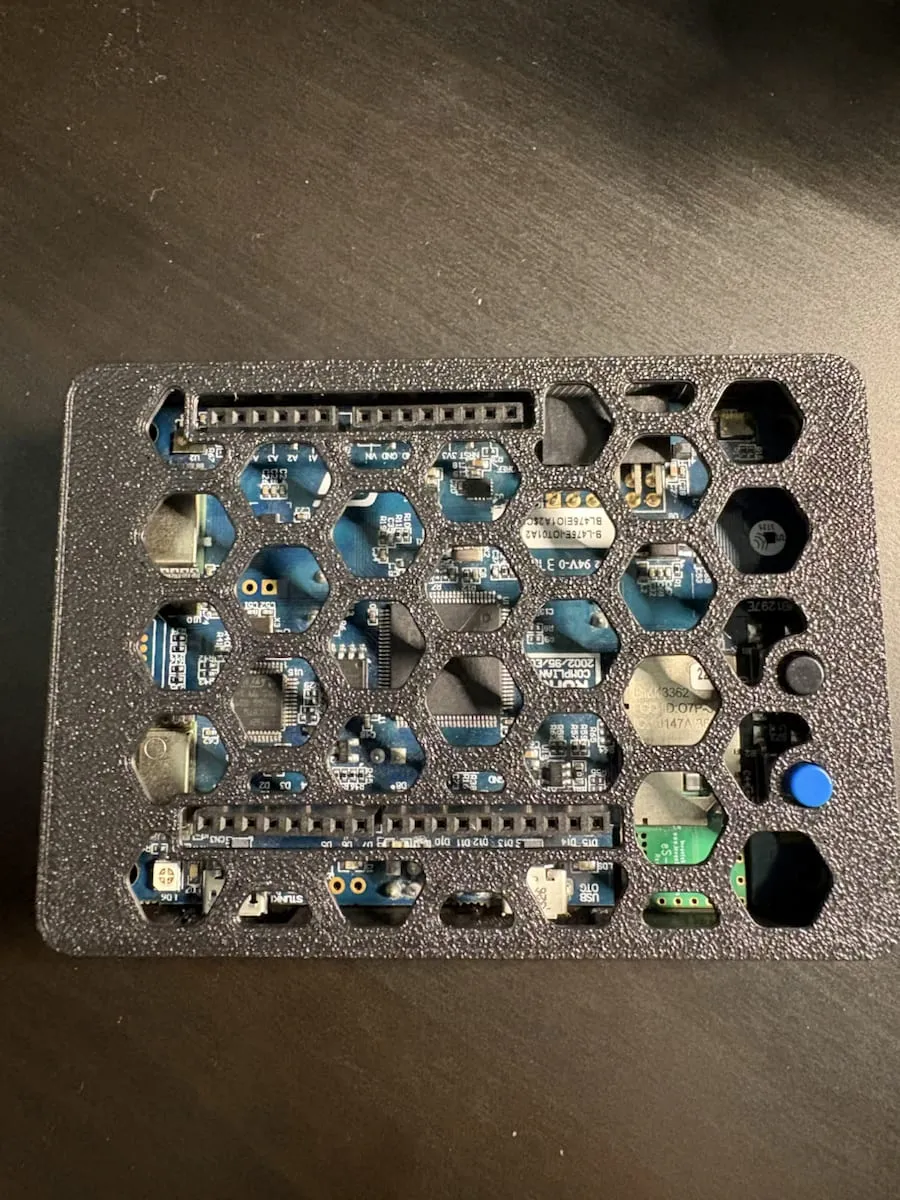 Top-down view of the vented 3D printed enclosure with the STM32 board visible through the hex pattern